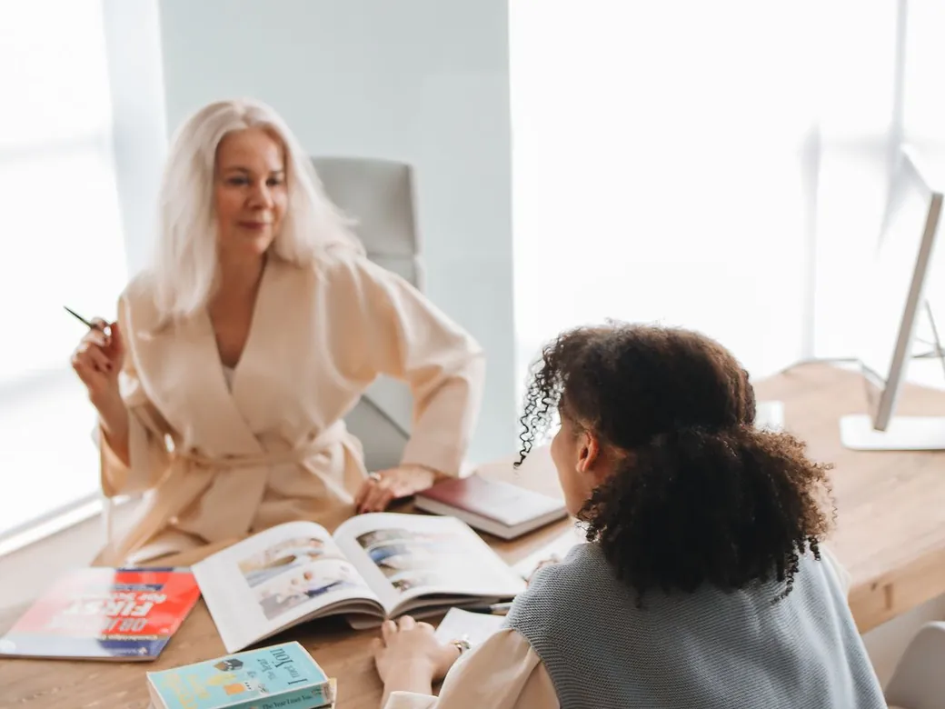 A tutor discussing an exam coursebook with an older student.